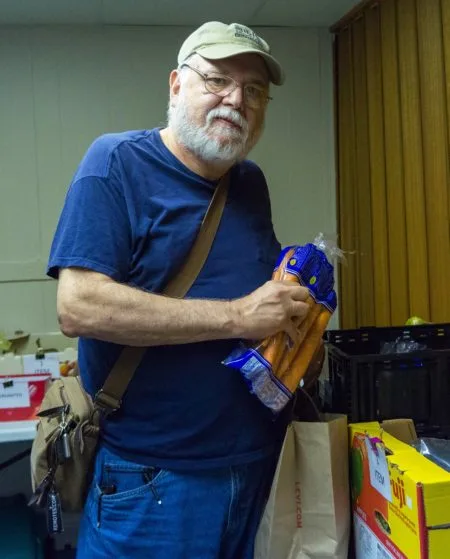 Gregory choosing a bag of carrots at a partner agency.