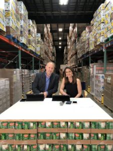 News Center Maine anchors broadcast from a desk made of pallets of canned food in the Auburn warehouse.