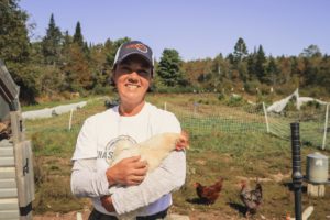 Anne Devin holds a chicken at Chase Stream Farm.