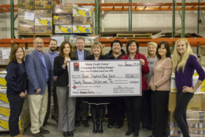Maine Credit Union League presents a donation for $20,000 at the Hampden distribution center.