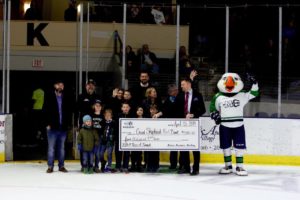Kristen Miale and other staff members accept a check to Good Shepherd Food Bank from the Maine Mariners.