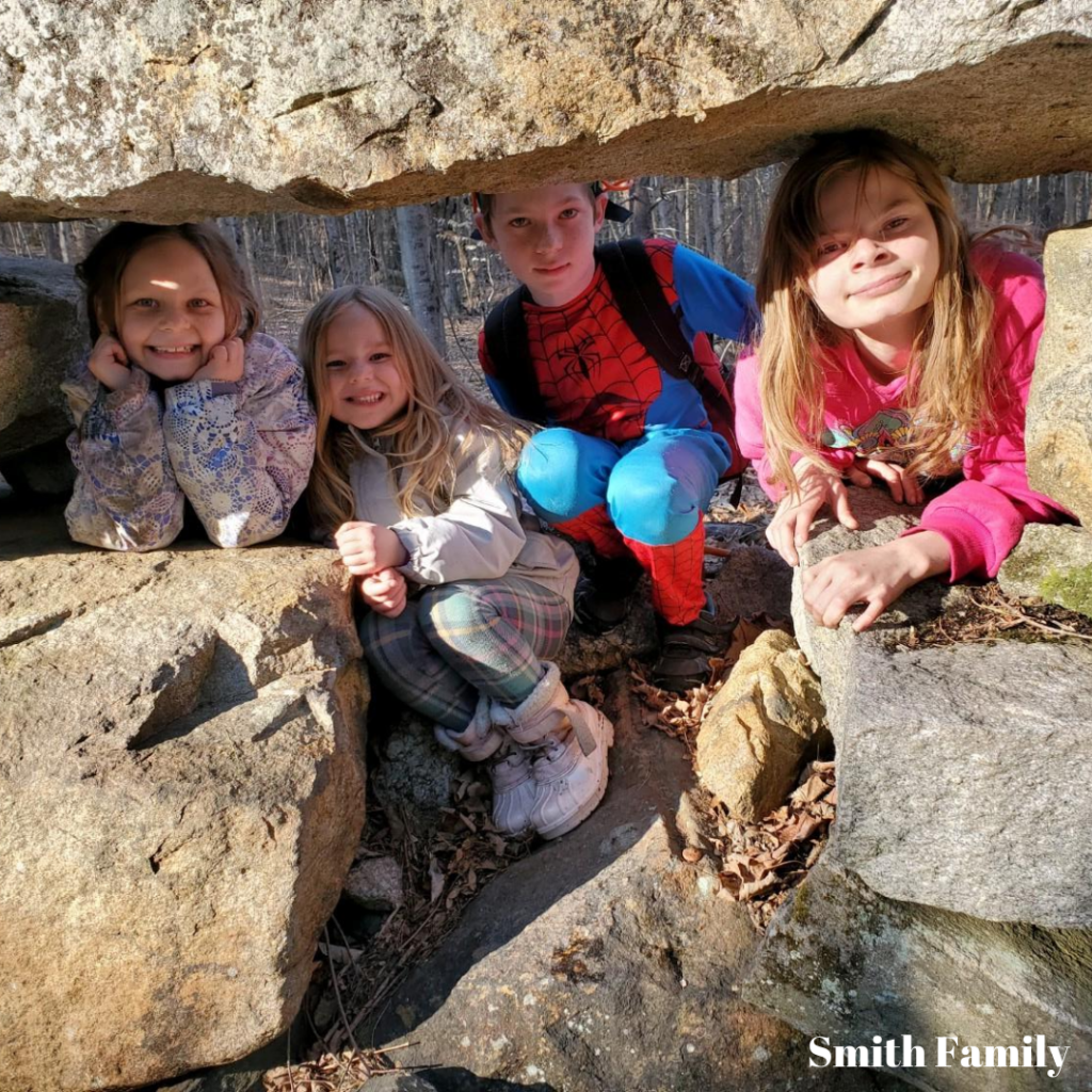 Four children in the Smith family sit among boulders.