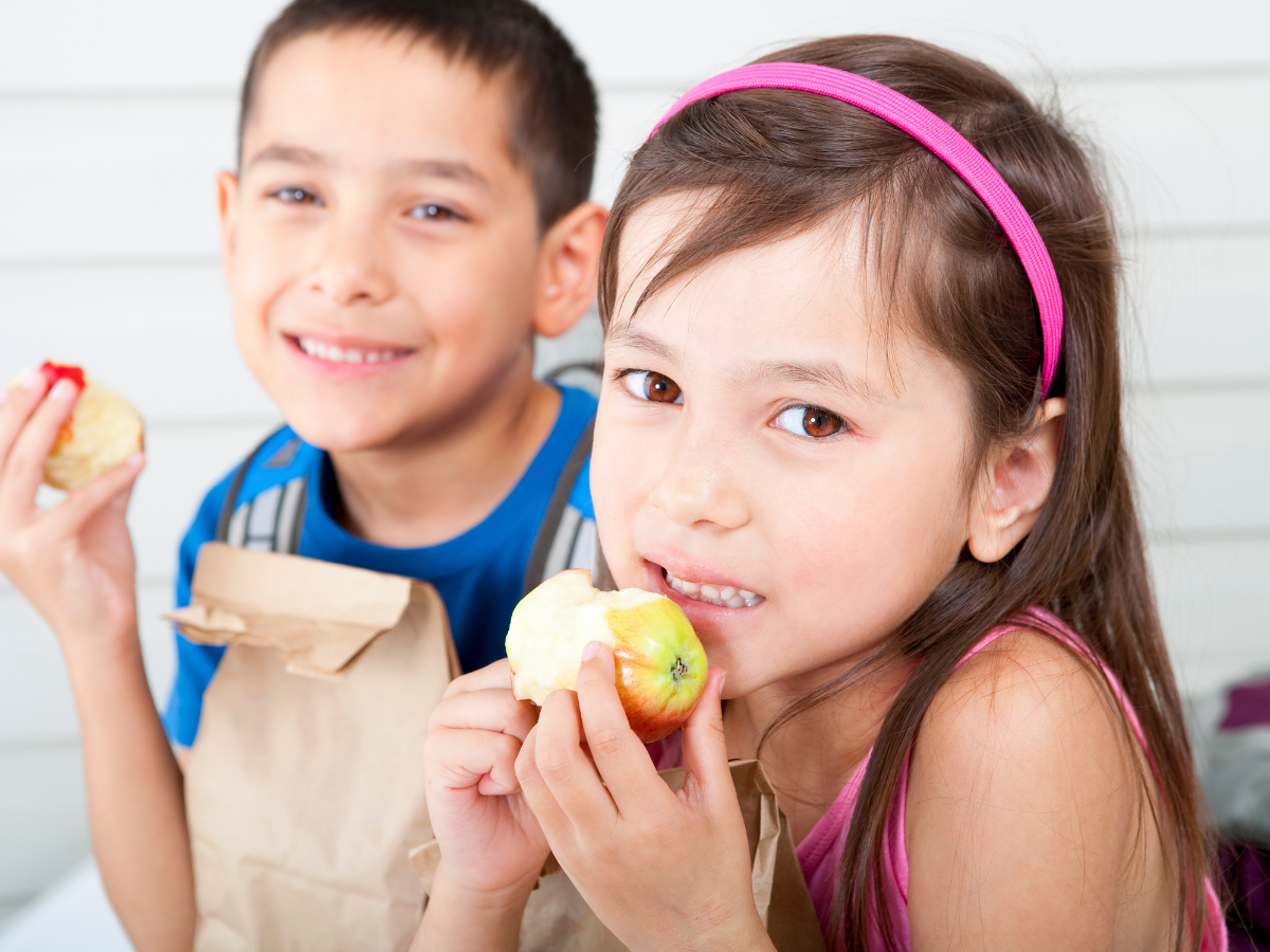 Two children eating apples