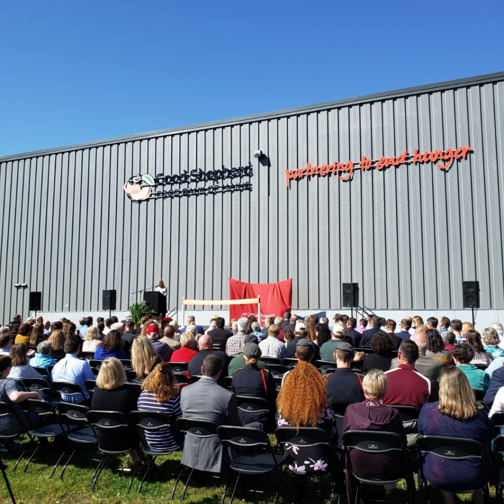Crowd gathered in front of the Hampden Distribution Center with Kristen Miale on stage