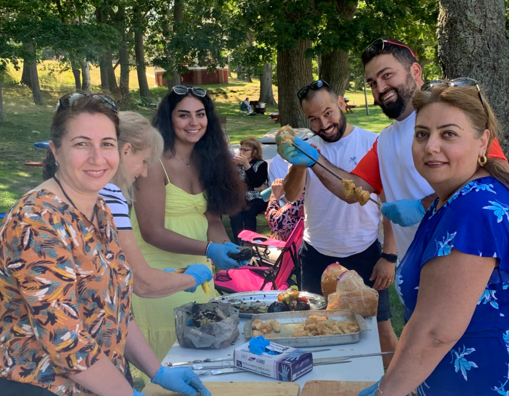 Volunteers around a table smiling with several different dishes.