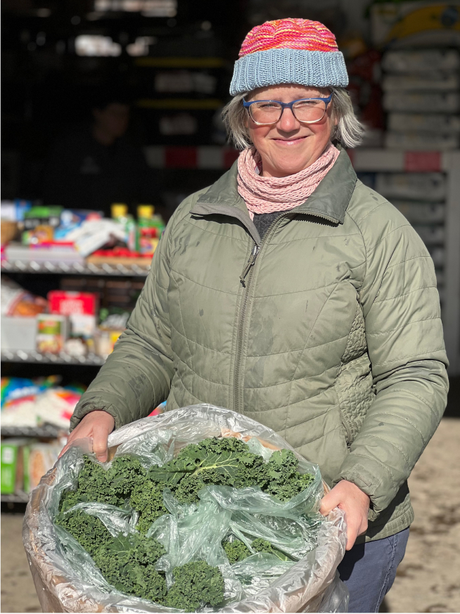 A Good Shepherd Food Bank team member holding fresh lettuce.