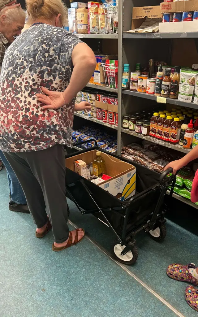 Neighbors select packaged food items at a partner agency.
