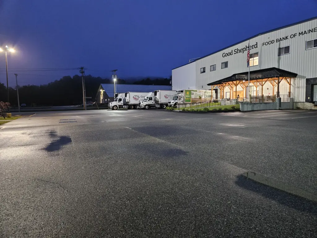 Good Shepherd Food Bank's Auburn-based distribution center at night with three trucks in the front