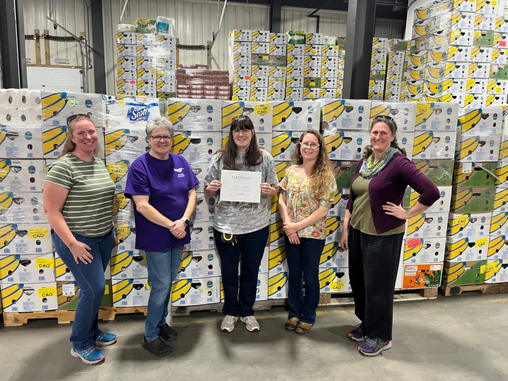 Five staff members volunteering in Auburn distribution center. Volunteers are from the Vermont Food Bank